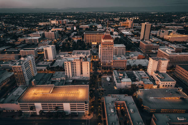 Aerial view of downtown Fresno at dusk, with the Pacific Southwest Building and surrounding city lit by warm evening light